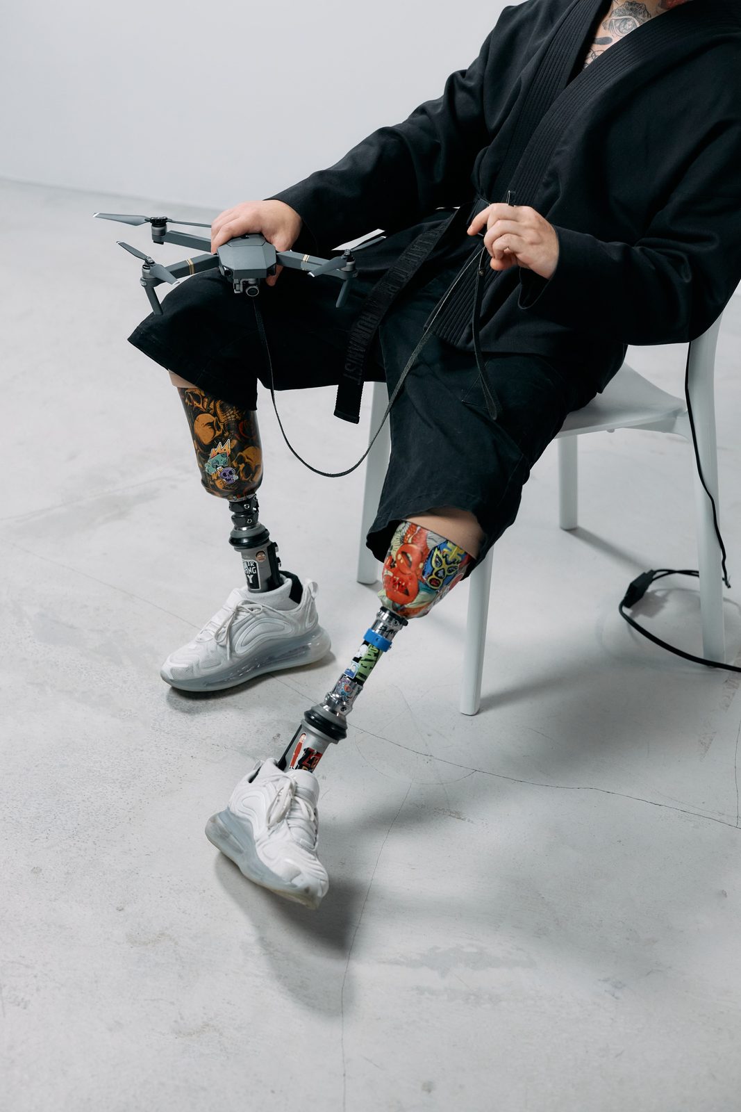 Person with prosthetic legs holding a drone